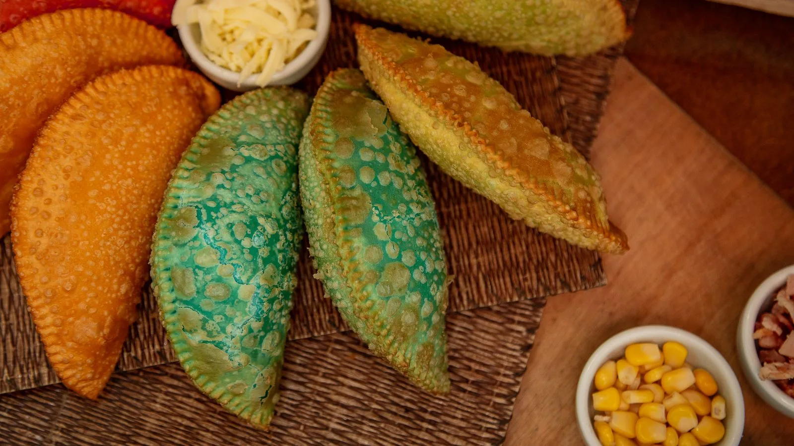 Vibrant Brazilian pastel arrangement served with corn and cheese for a delightful snack.