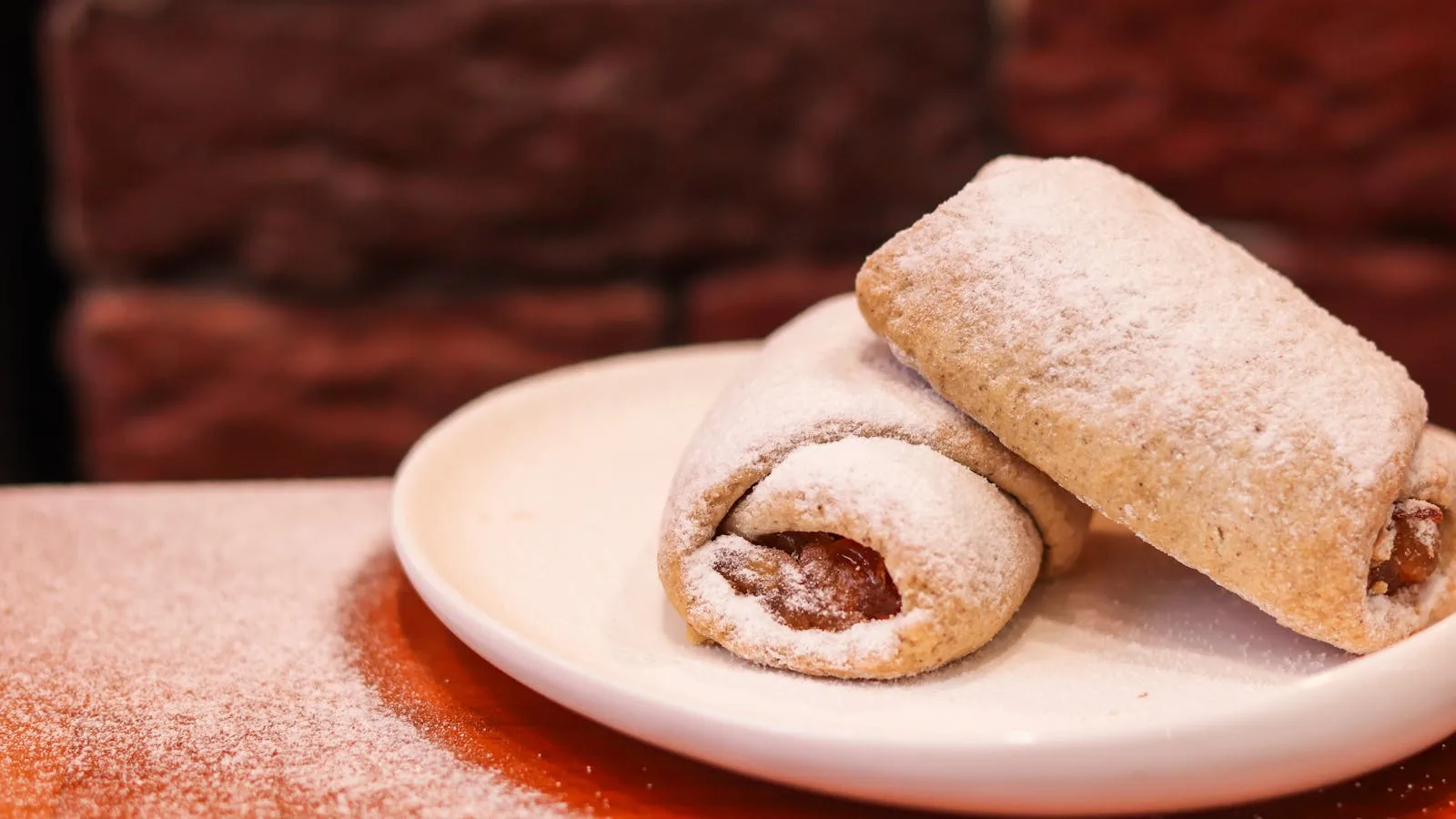 Delicious apple jam-filled cookies with powdered sugar on a plate, perfect for dessert.