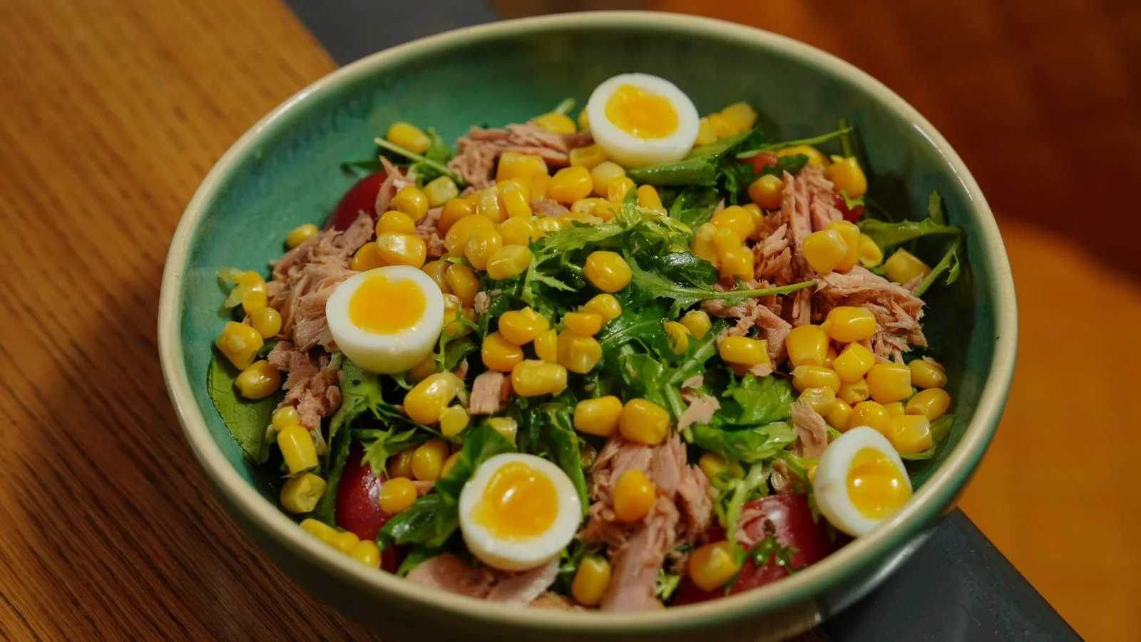 A vibrant bowl of tuna salad with corn and quail eggs for a healthy meal.