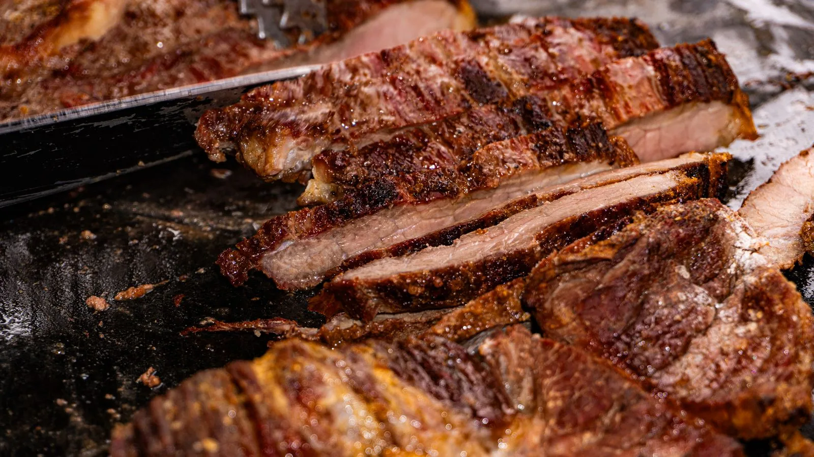 Close-up of sliced grilled beef with rich seasoning at a traditional Brazilian barbecue in Londrina.