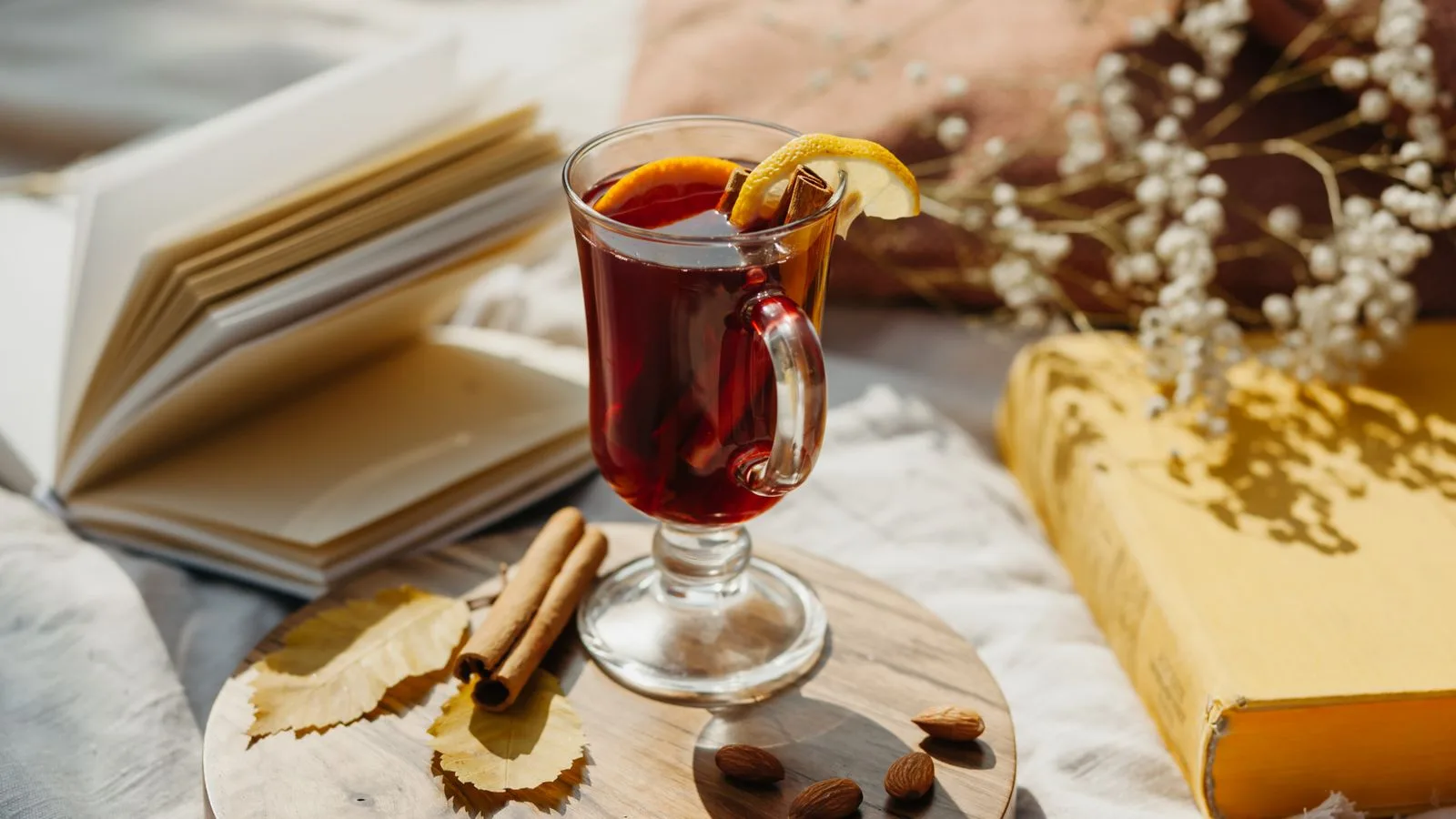 Warm mulled wine with cinnamon and books, perfect for a cozy autumn afternoon.