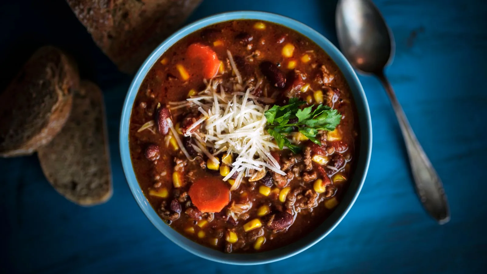 Delicious homemade beef chili served with fresh bread on a rustic table for a cozy meal.