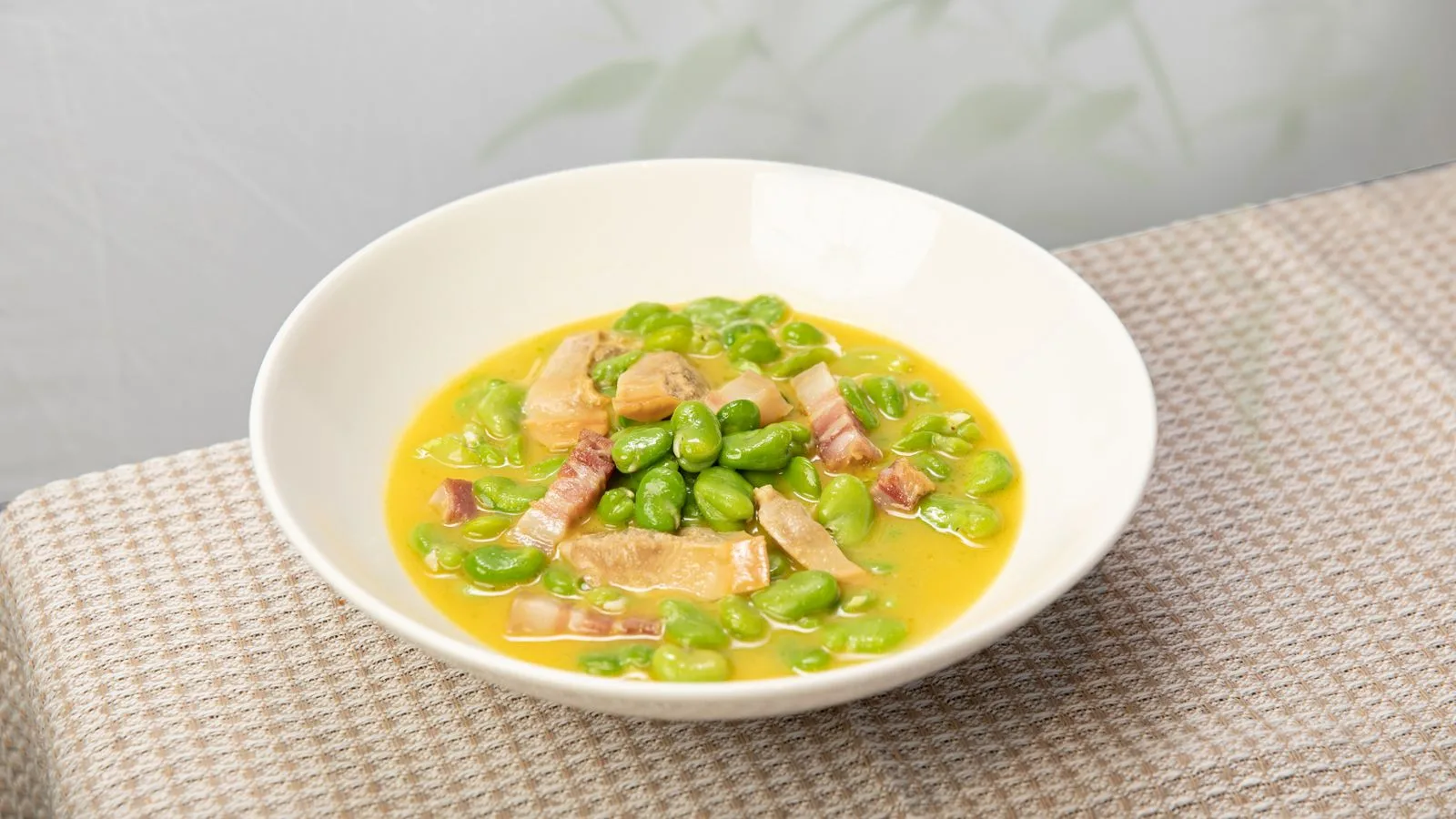 A bowl of savory fava bean and bacon stew, perfect for a comforting meal.
