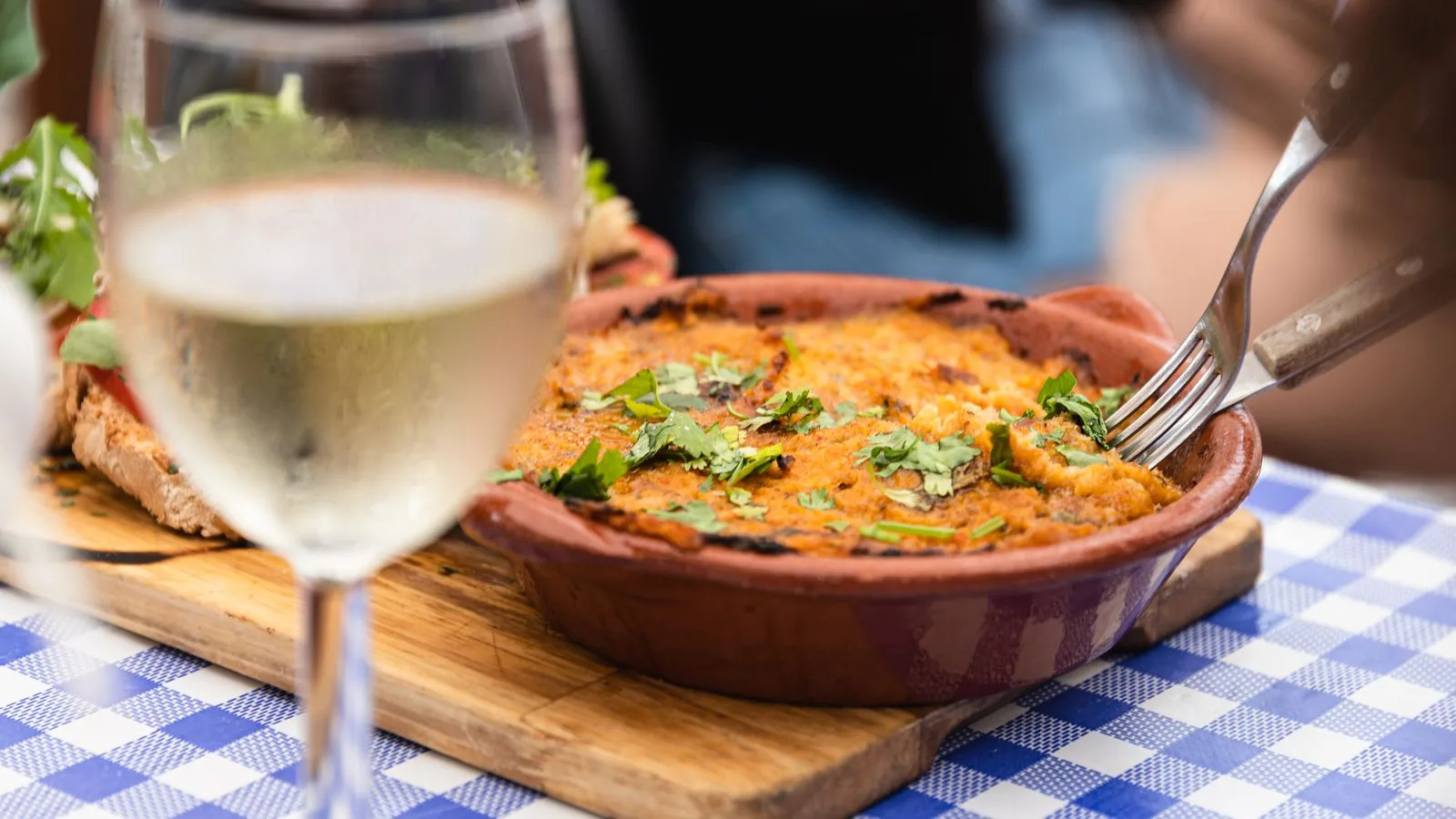A delicious Portuguese dish served with white wine in a restaurant setting in Faro, Portugal.