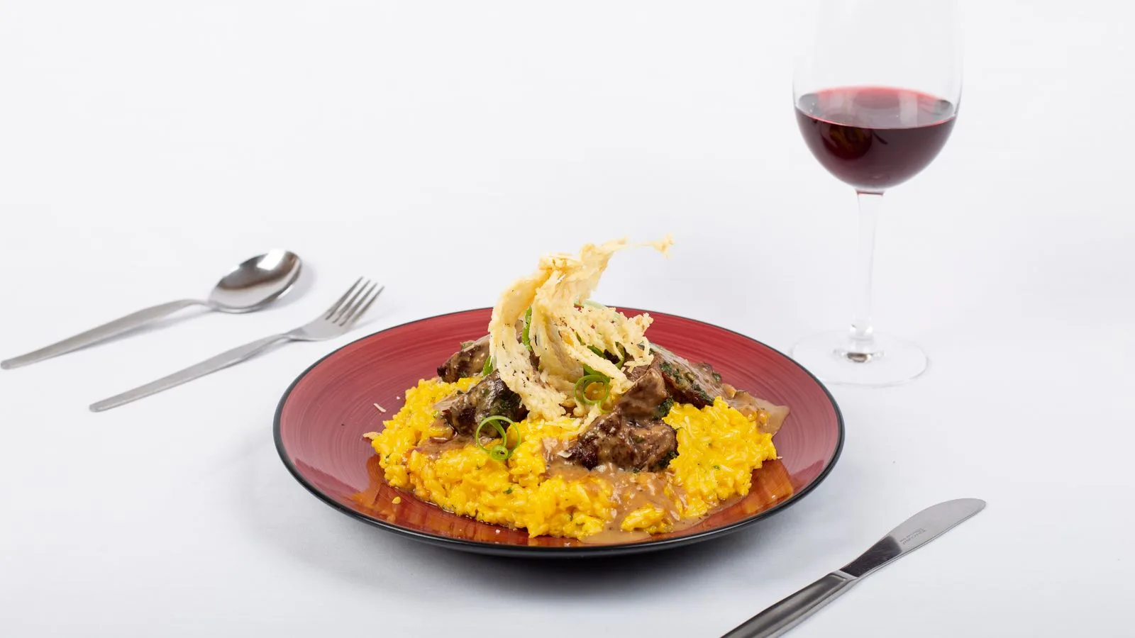Exquisite fine dining meal with yellow rice and wine, perfect for gourmet enthusiasts.