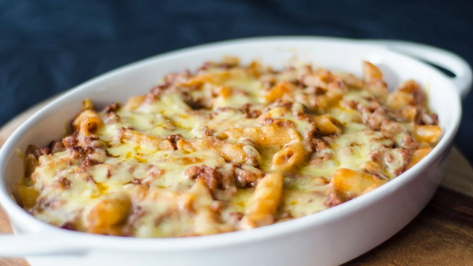 Close-up of a homemade baked macaroni and cheese in a white dish. Perfect comfort food for lunch or dinner.