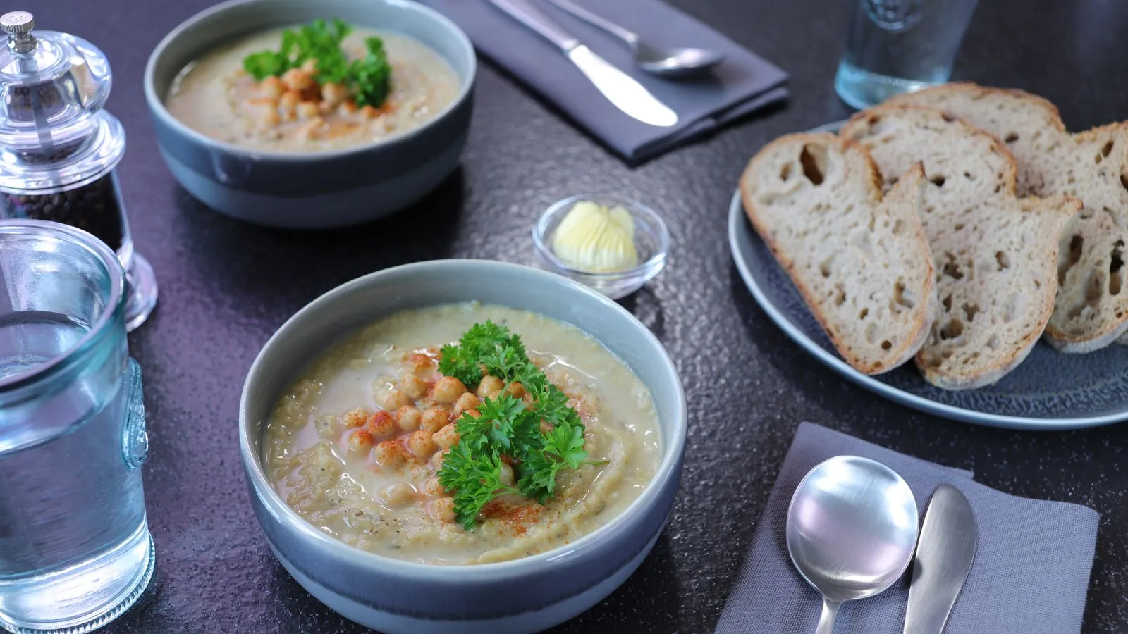 Delicious homemade chickpea soup served with fresh bread and garnished with parsley.