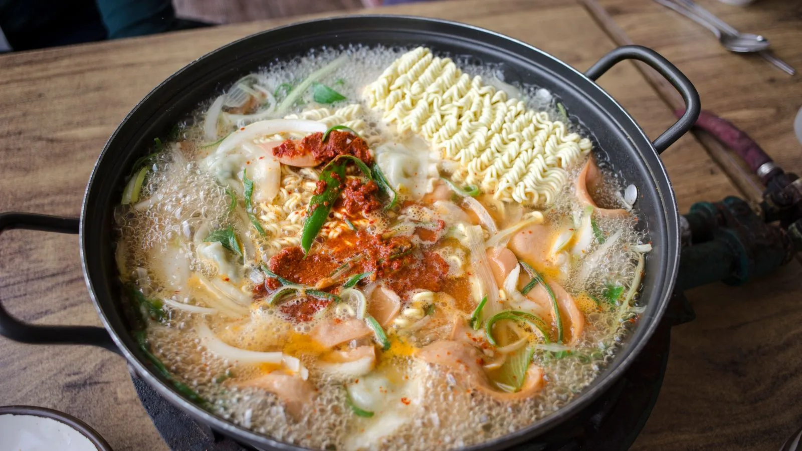 Delicious and spicy Korean ramen soup with vegetables boiling in a pan, capturing the essence of authentic Asian cuisine.