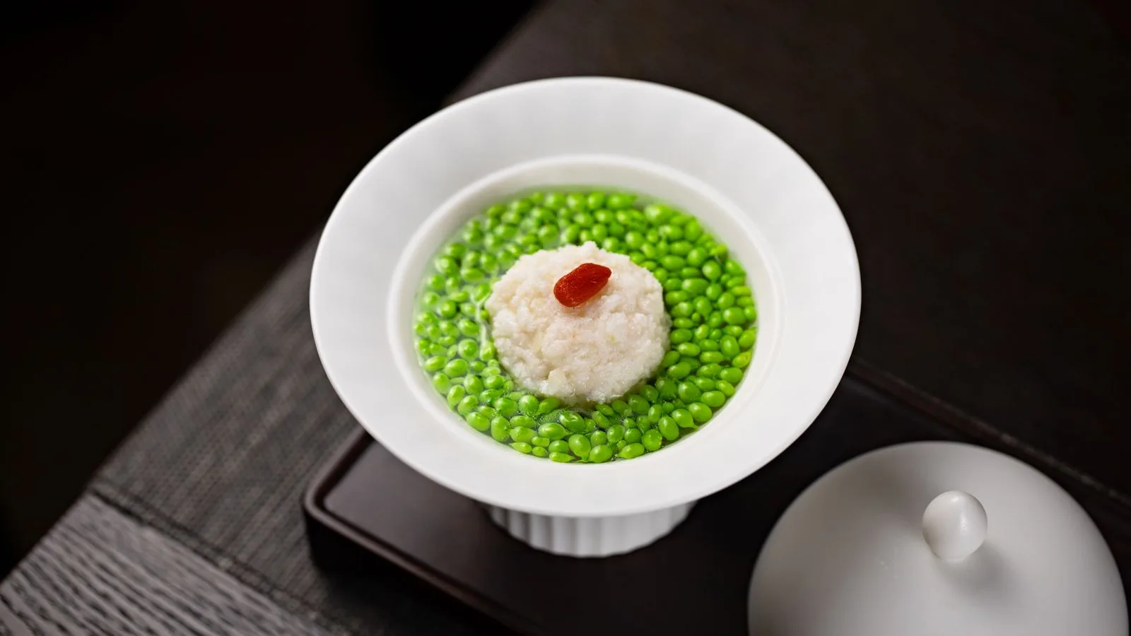 A gourmet soup dish featuring green peas and rice in a white bowl, perfect for food photography.