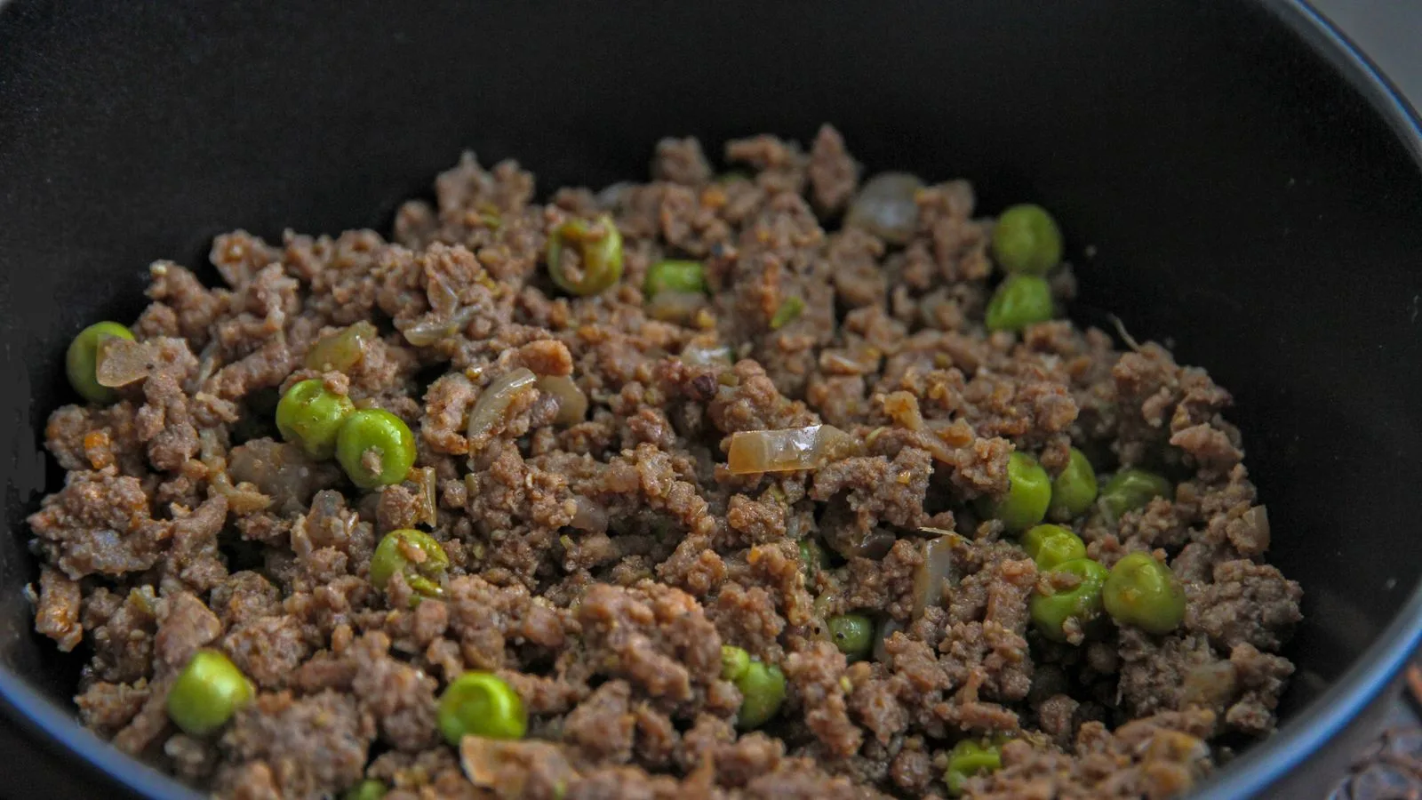 Close-up of a savory dish with minced meat and peas, ideal for culinary themes.