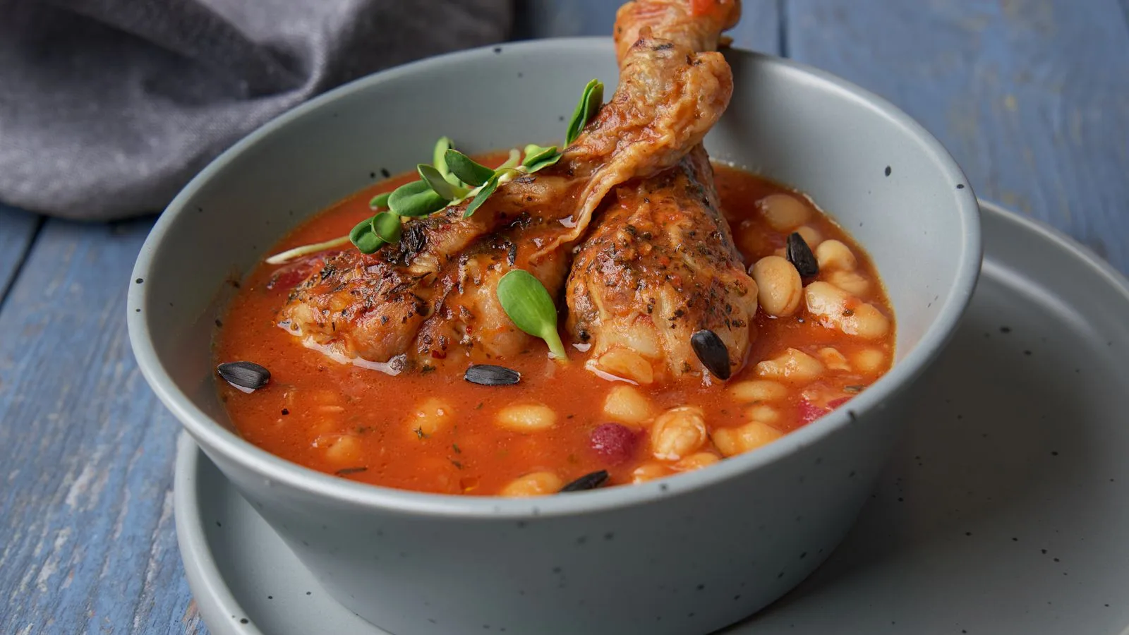 Savor the taste of hearty chicken and bean stew served in a blue ceramic bowl.