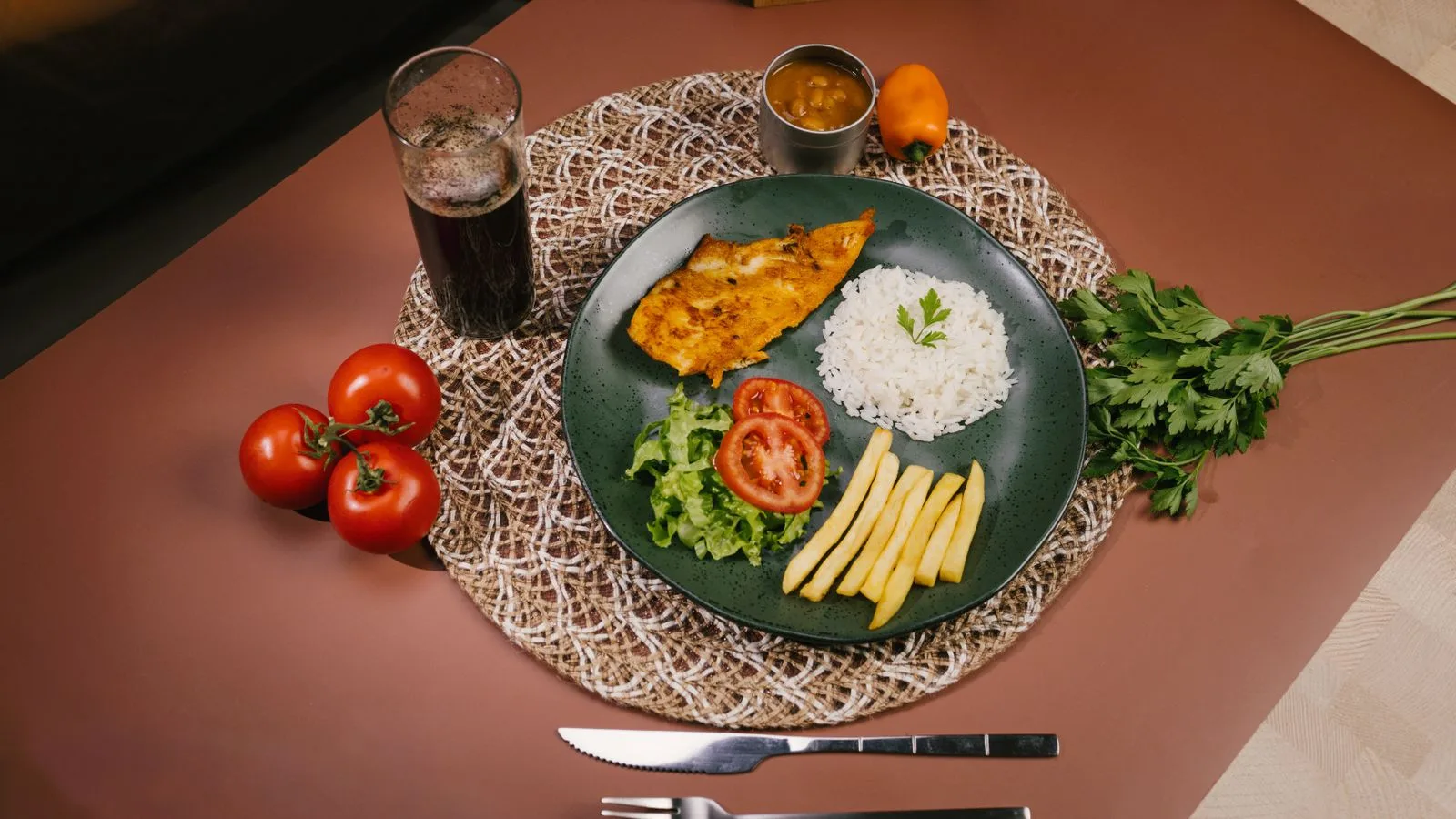 A delicious traditional Brazilian dinner featuring fish, rice, and vegetables.